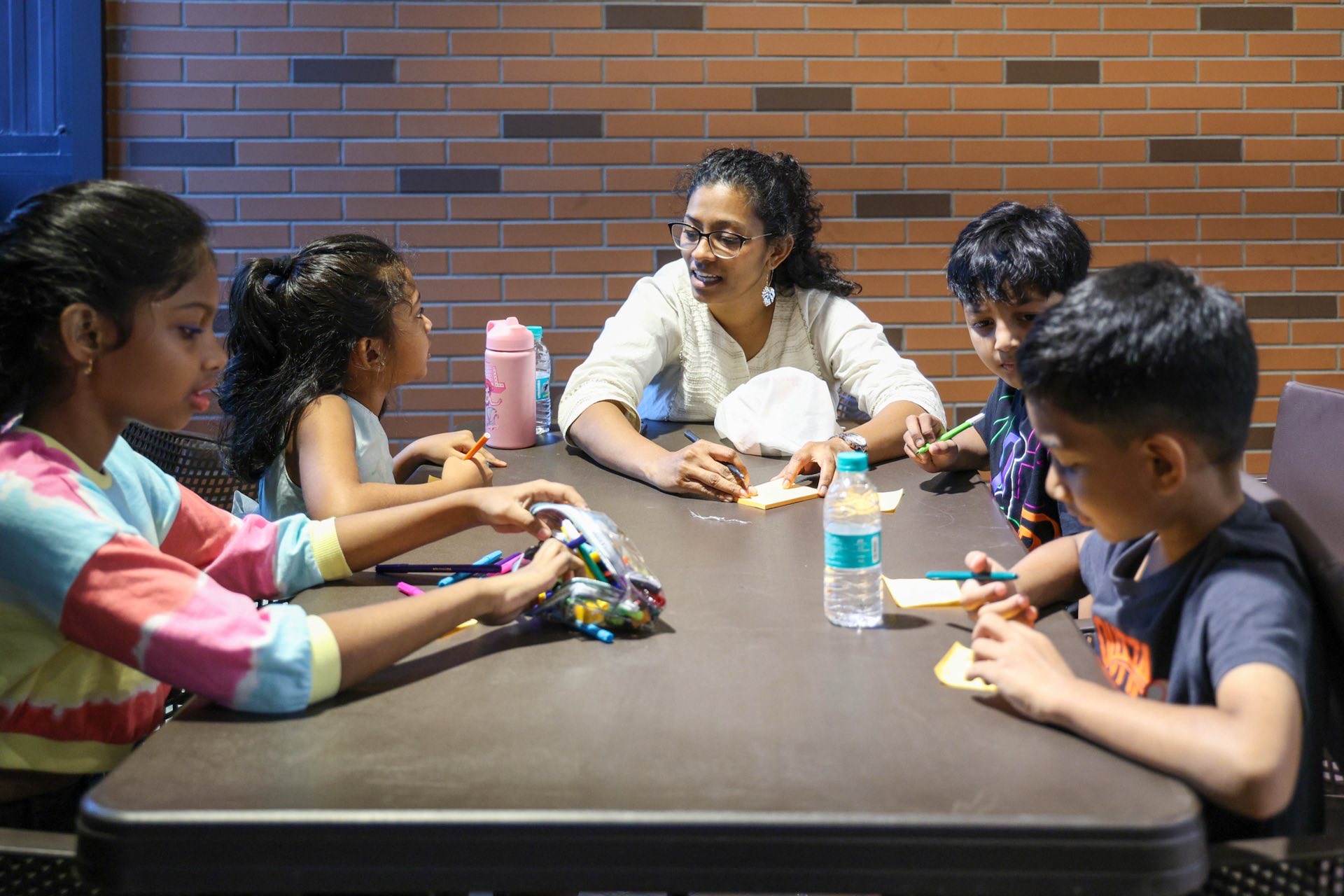 Freedom Kids leader with children at a table