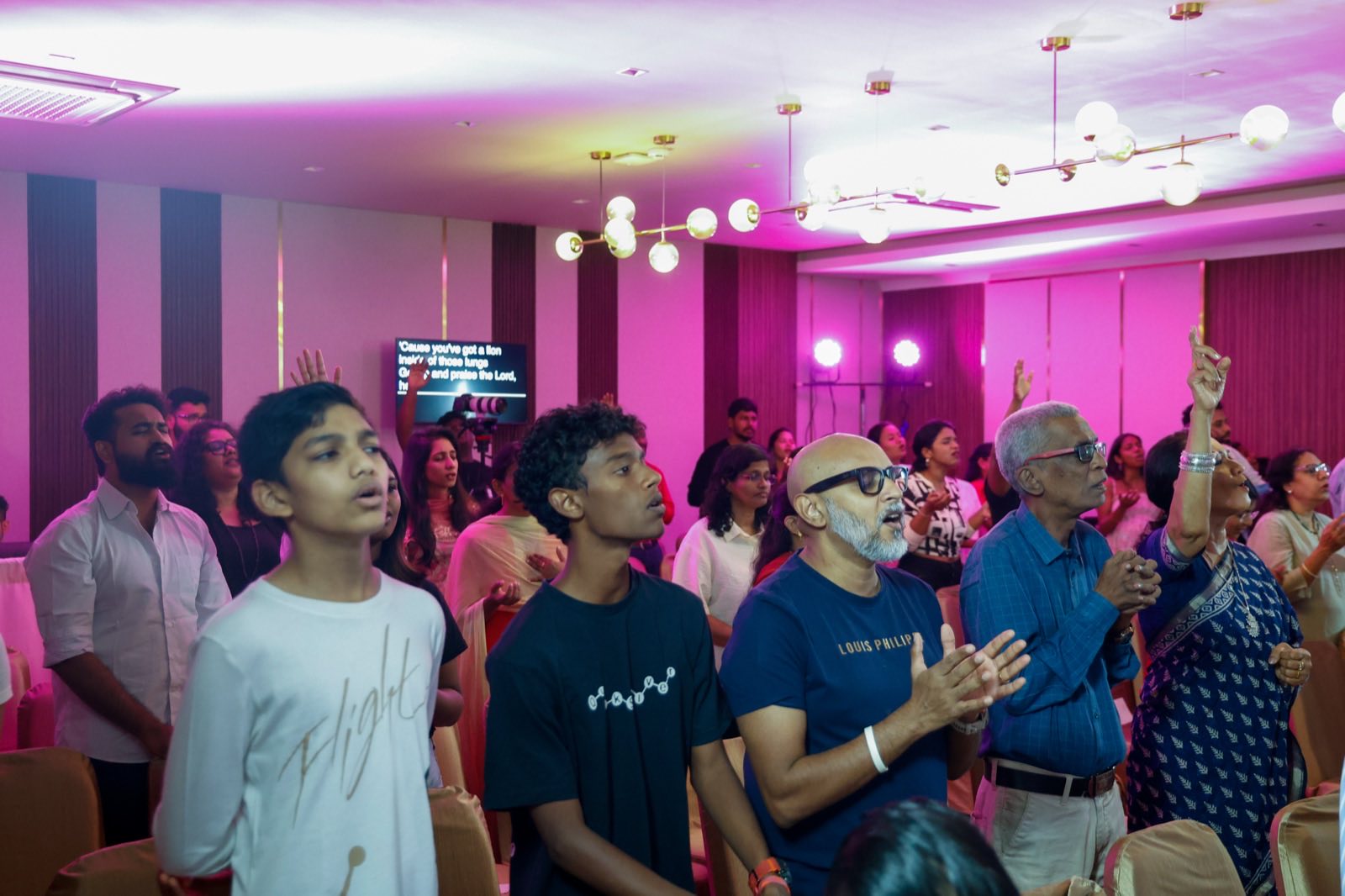 Congregation of all ages singing together during a Sunday worship service