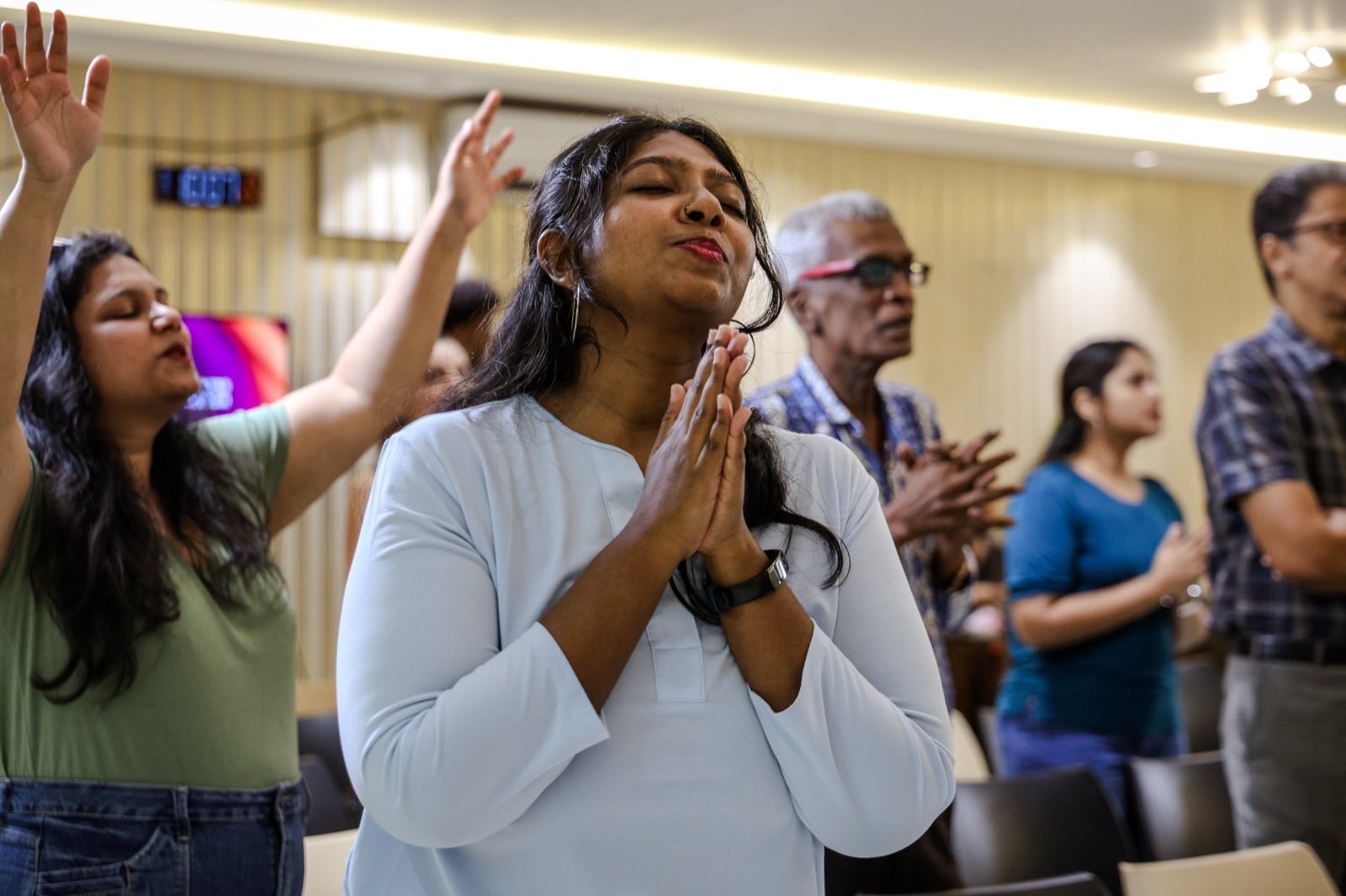 Congregation praying and worshipping together with hands raised